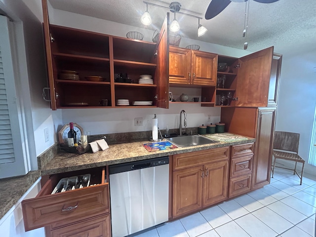 kitchen featuring a textured ceiling, dishwasher, light tile patterned flooring, and sink