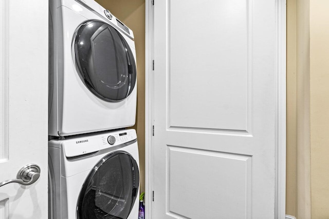 clothes washing area with stacked washer / dryer