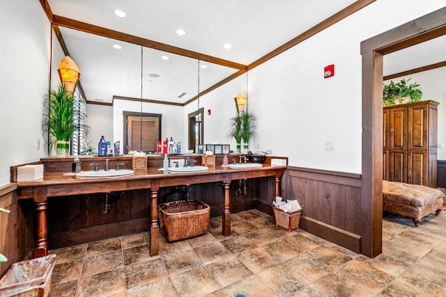 bathroom featuring ornamental molding, vanity, and wooden walls