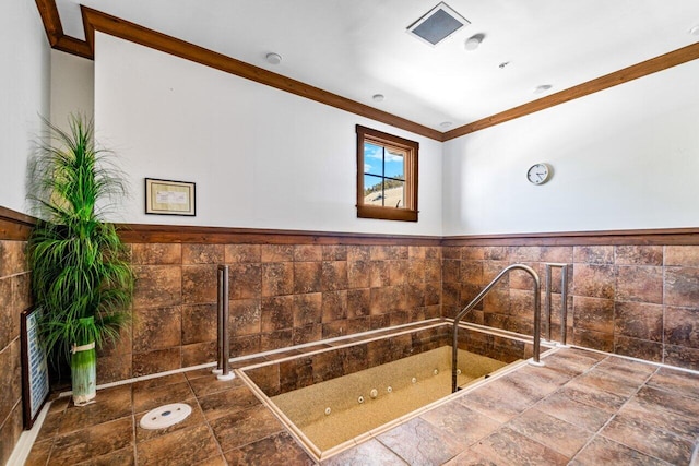 bathroom with crown molding and tile walls