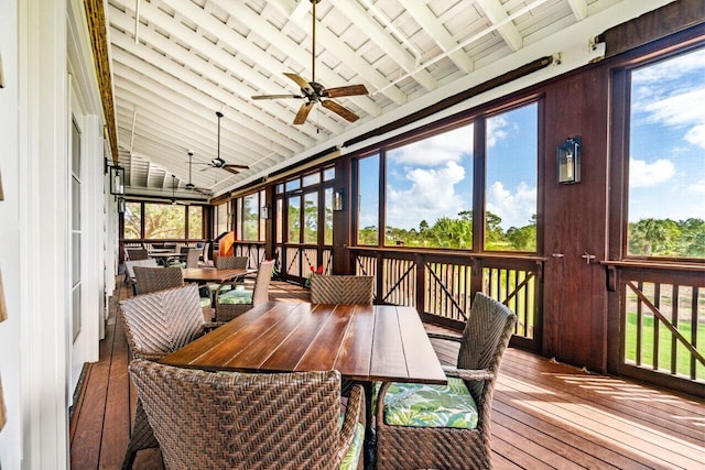 sunroom featuring lofted ceiling with beams, ceiling fan, and a healthy amount of sunlight