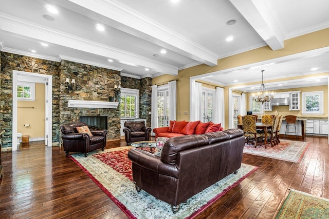 living room featuring dark wood-type flooring, a fireplace, an inviting chandelier, and beam ceiling