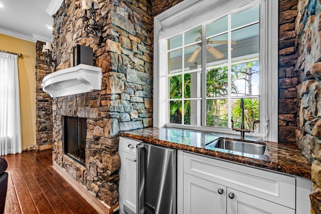 kitchen with white cabinets, dark hardwood / wood-style floors, dark stone counters, and crown molding