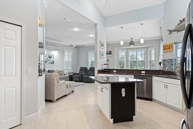 kitchen featuring white cabinets, a kitchen island, ceiling fan, decorative light fixtures, and stainless steel dishwasher