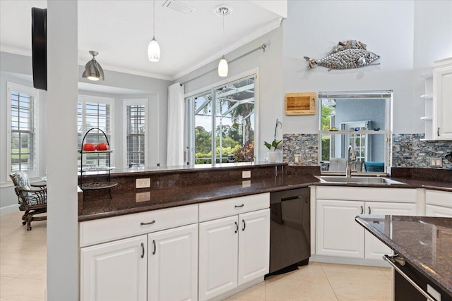 kitchen featuring dishwasher, dark stone counters, plenty of natural light, and white cabinetry