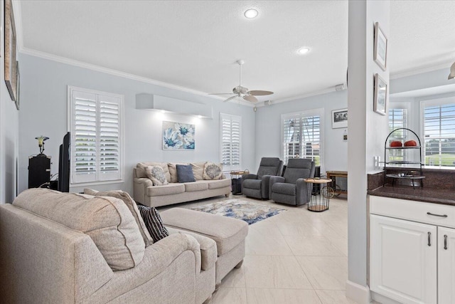 living room with ornamental molding, ceiling fan, and plenty of natural light