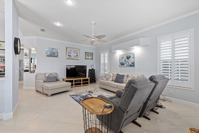 living area with a ceiling fan, baseboards, crown molding, and visible vents
