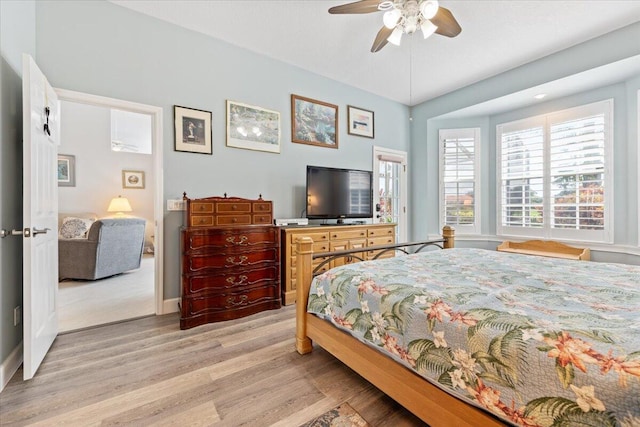 bedroom with light wood-style flooring, baseboards, and a ceiling fan