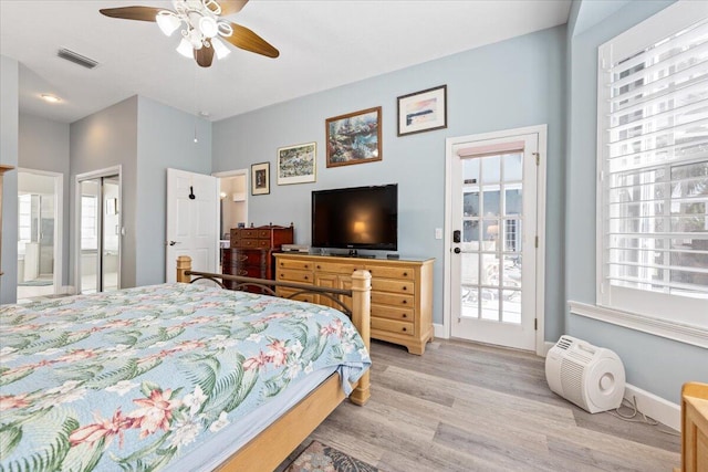 bedroom with ceiling fan, light wood-type flooring, ensuite bathroom, and multiple windows