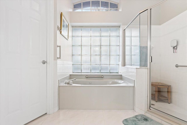 bathroom with a bath, a shower stall, and tile patterned floors