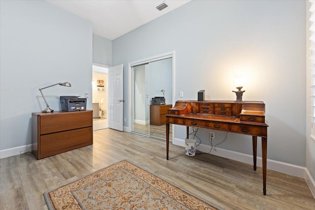 home office with baseboards, wood finished floors, and visible vents