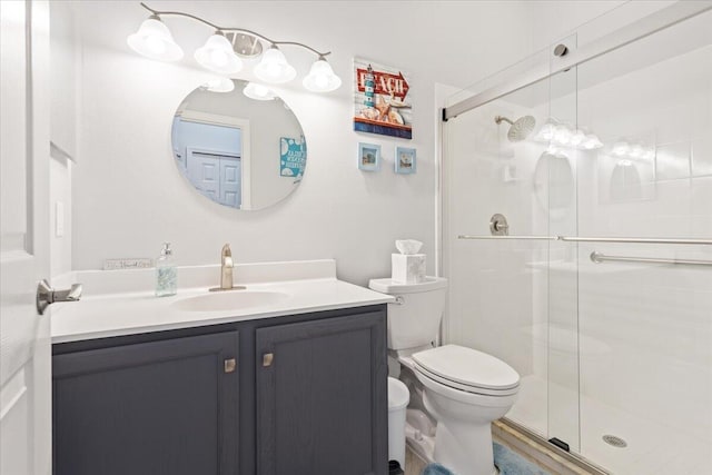 bathroom with vanity, a shower stall, and toilet
