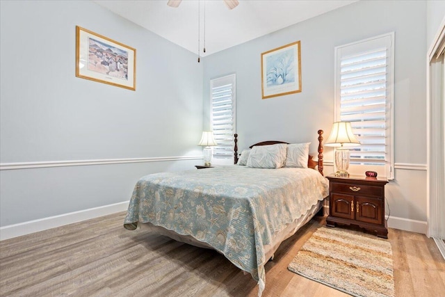 bedroom featuring ceiling fan, baseboards, and light wood finished floors
