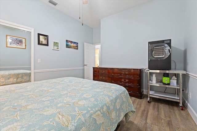 bedroom featuring wood-type flooring, high vaulted ceiling, and ceiling fan