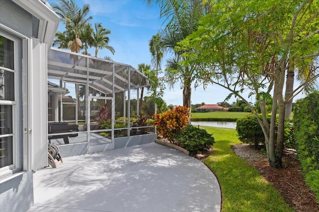 view of patio with a lanai and a water view