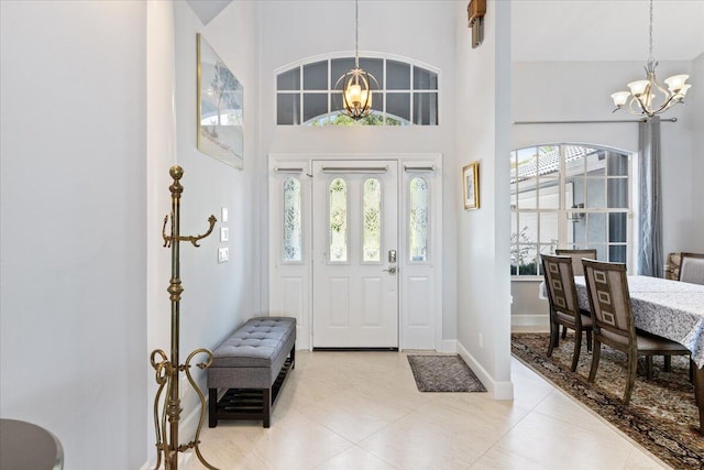 tiled entryway featuring an inviting chandelier and a towering ceiling