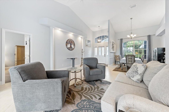 living room featuring baseboards, high vaulted ceiling, and an inviting chandelier