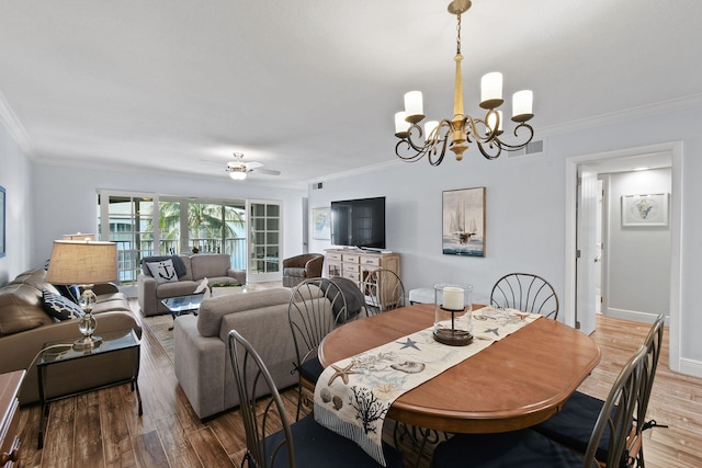 dining area with ceiling fan with notable chandelier, hardwood / wood-style floors, and crown molding