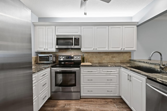 kitchen featuring stainless steel appliances, white cabinets, ceiling fan, and sink