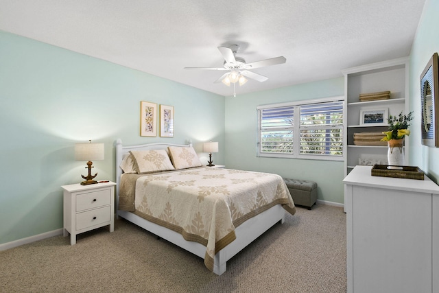 carpeted bedroom with ceiling fan and a textured ceiling