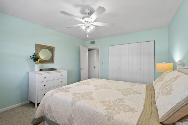 bedroom with ceiling fan, light colored carpet, and a closet