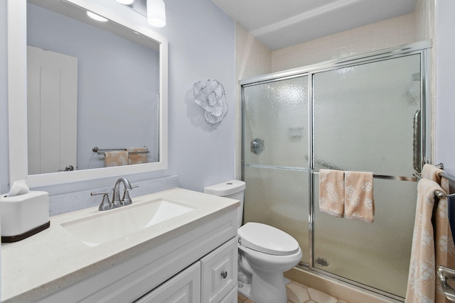 bathroom with tile patterned flooring, vanity, toilet, and a shower with shower door