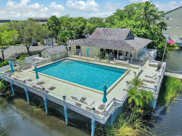 view of swimming pool with a patio and a water view