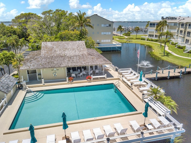 view of swimming pool featuring a patio and a water view