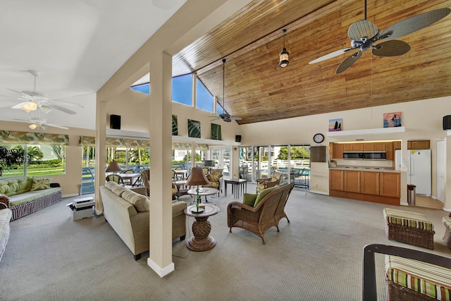 living room with ceiling fan, light carpet, high vaulted ceiling, and a healthy amount of sunlight