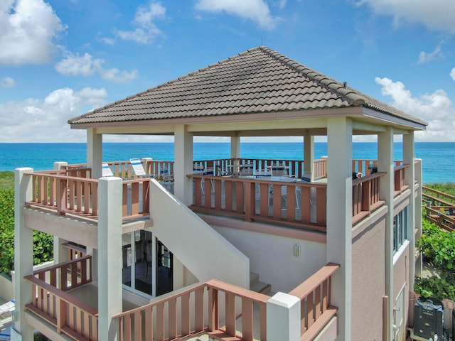 back of property featuring a water view and a balcony