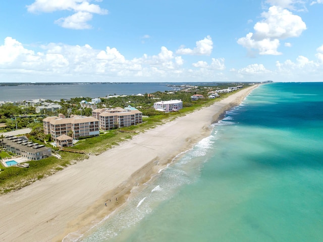 birds eye view of property featuring a beach view and a water view