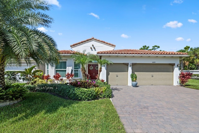 mediterranean / spanish-style home featuring a garage and a front lawn