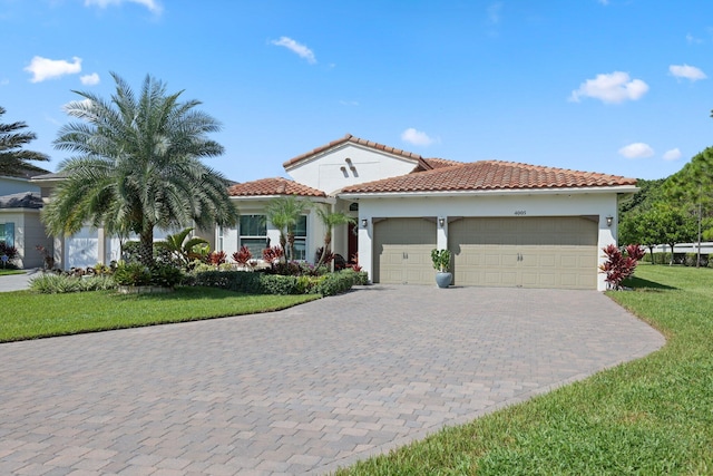 mediterranean / spanish home featuring a front yard and a garage