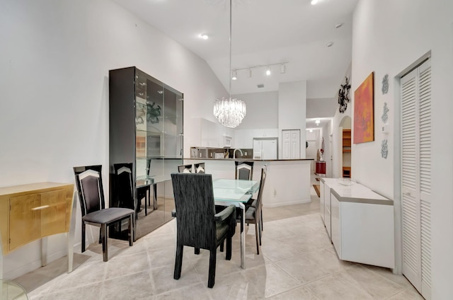 dining space with rail lighting, a chandelier, and light tile patterned floors