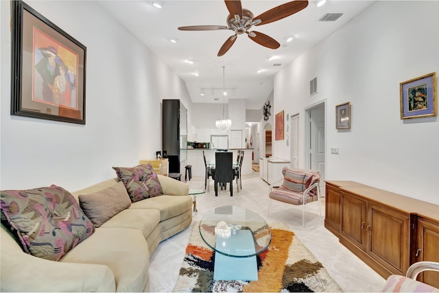 living room with ceiling fan with notable chandelier and a towering ceiling