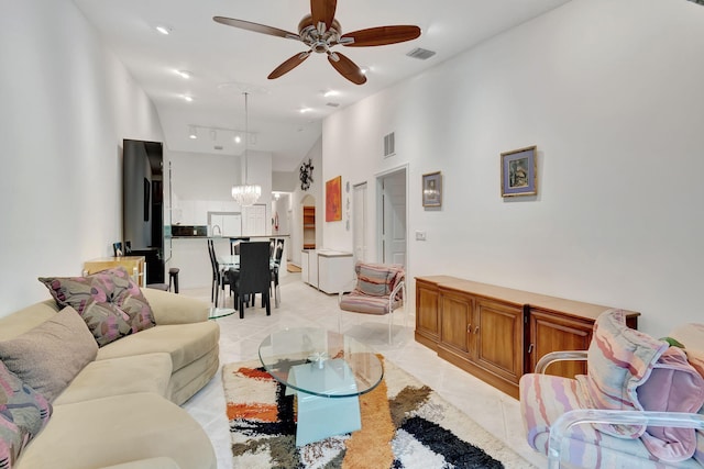 living room featuring light tile patterned flooring, high vaulted ceiling, and ceiling fan with notable chandelier