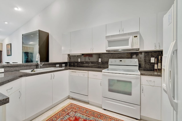 kitchen with lofted ceiling, backsplash, sink, white cabinetry, and white appliances