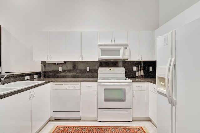 kitchen featuring decorative backsplash, sink, light tile patterned floors, white cabinets, and white appliances