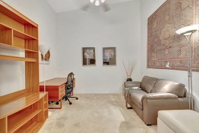 carpeted office space featuring ceiling fan and high vaulted ceiling