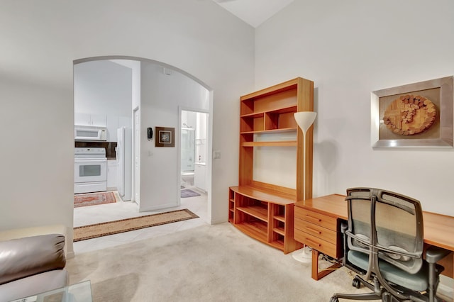 carpeted office featuring high vaulted ceiling