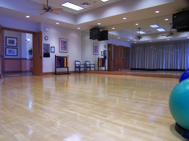 workout area featuring light wood-type flooring and ceiling fan