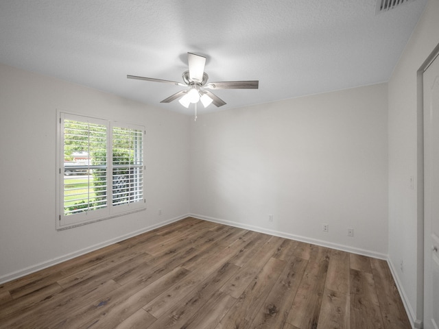 unfurnished room featuring a textured ceiling, hardwood / wood-style floors, and ceiling fan