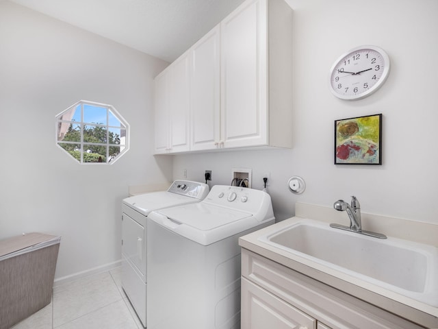 laundry area with cabinets, washing machine and clothes dryer, light tile patterned flooring, and sink