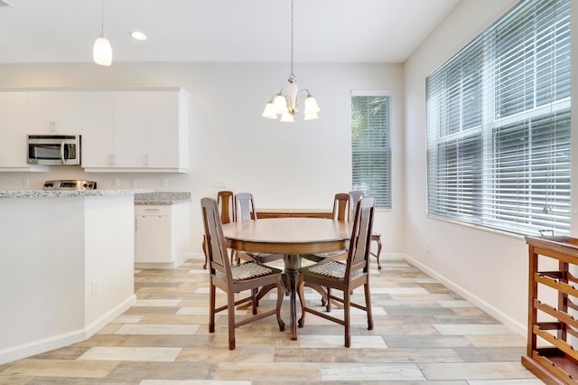 dining room with light hardwood / wood-style floors and a chandelier