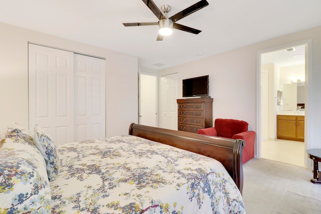 bedroom with ensuite bath, ceiling fan, and light colored carpet