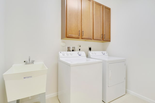 washroom with cabinets, separate washer and dryer, sink, and light tile patterned floors