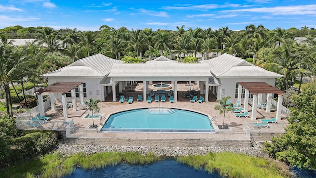 back of property with a water view, a pergola, and a patio