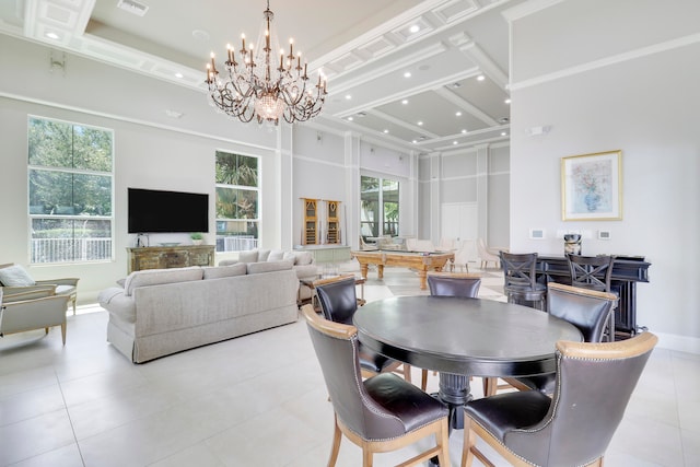 tiled dining area featuring a raised ceiling, a high ceiling, and a chandelier