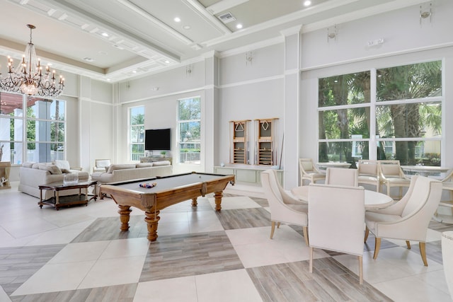 recreation room featuring light tile patterned floors, a towering ceiling, billiards, and a chandelier