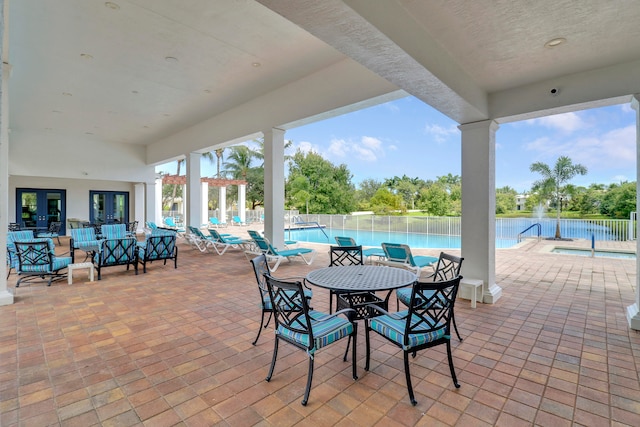 view of patio / terrace with an outdoor living space, a water view, and a community pool